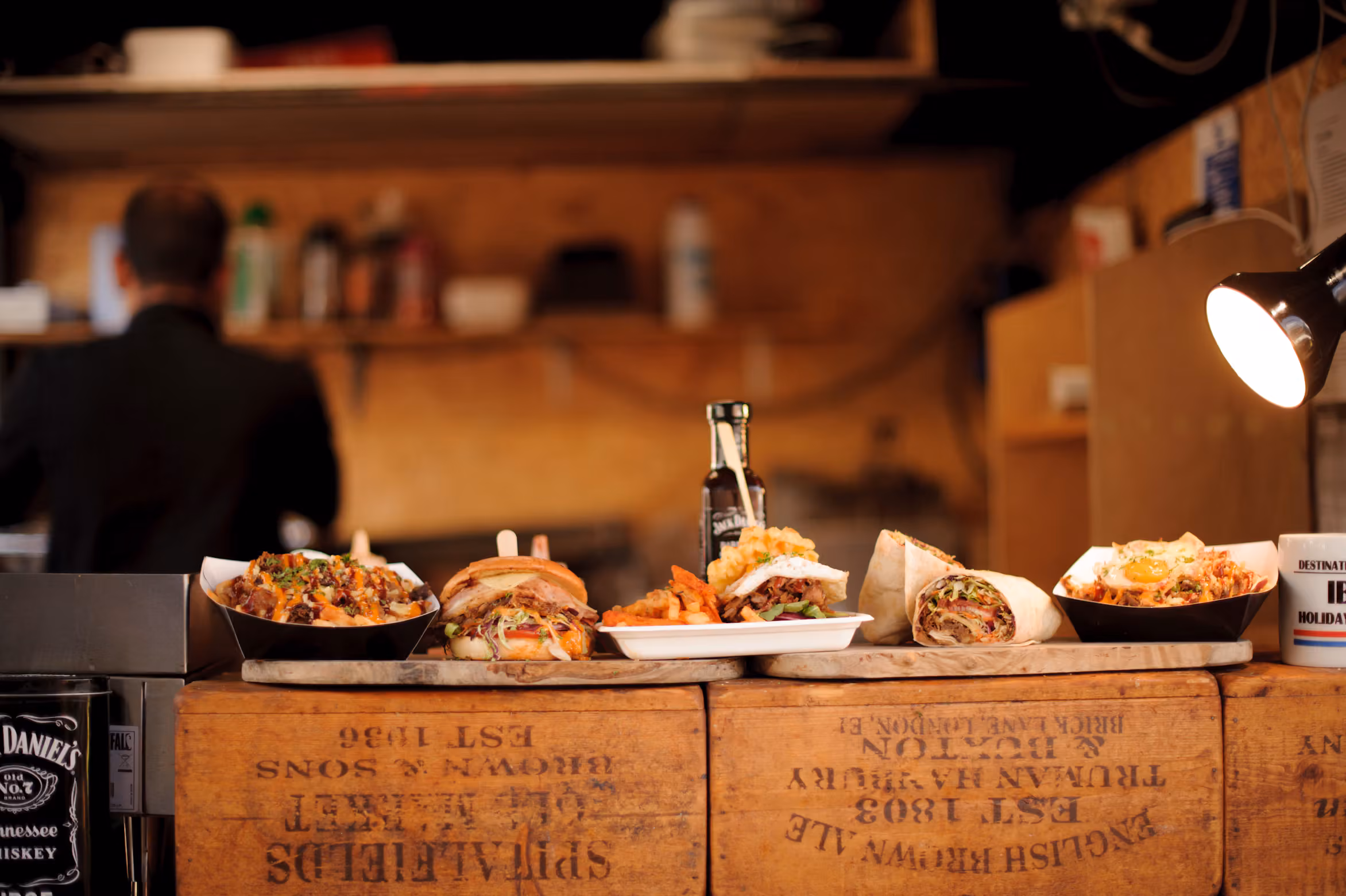 Prepared street-food dishes displayed on a wooden market counter