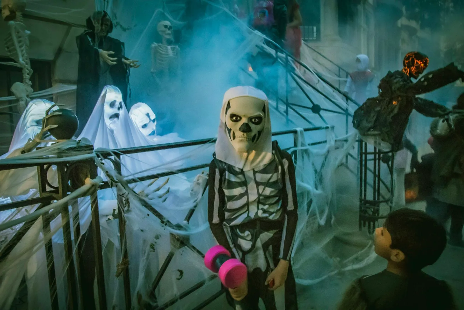 Enfant déguisé en squelette près de décorations de fantômes