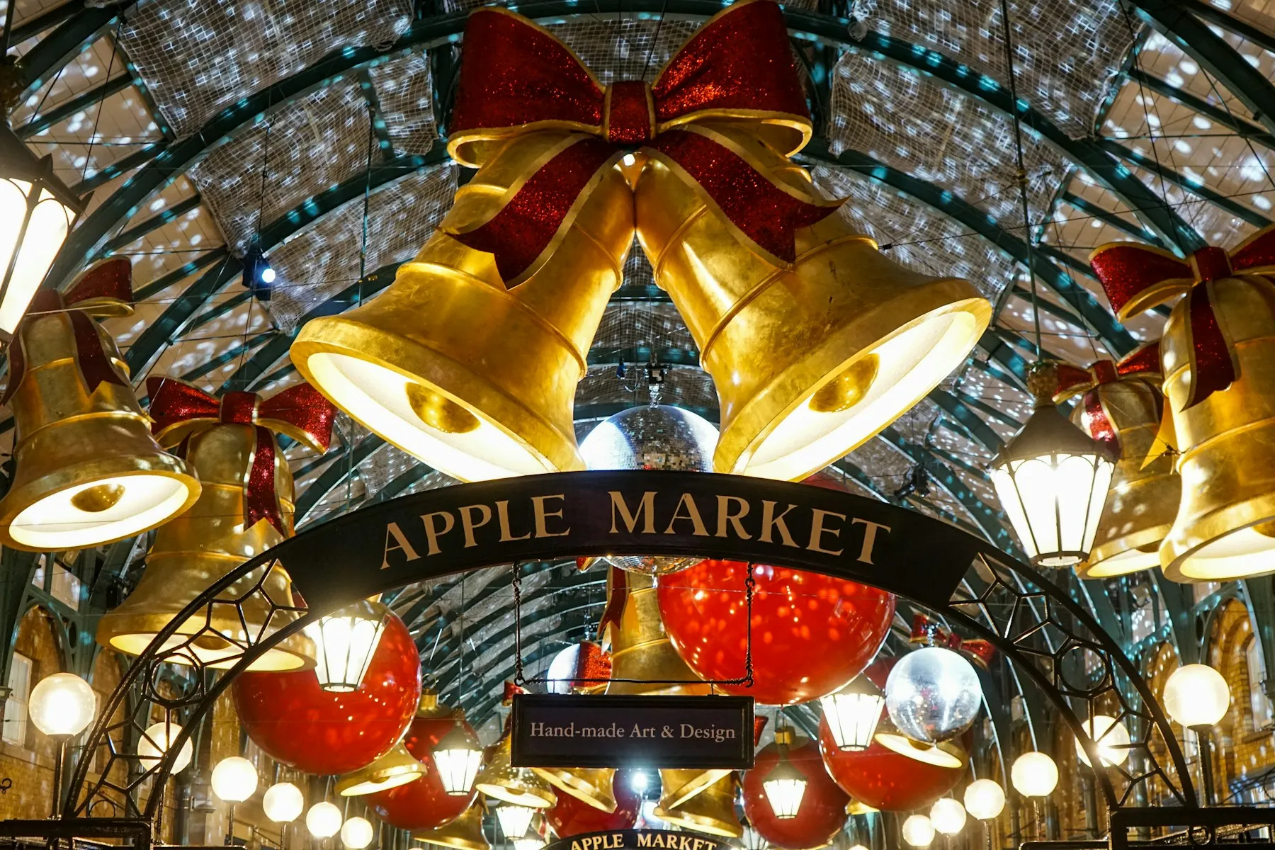 Giant illuminated Christmas bells and baubles inside Covent Garden's Apple Market