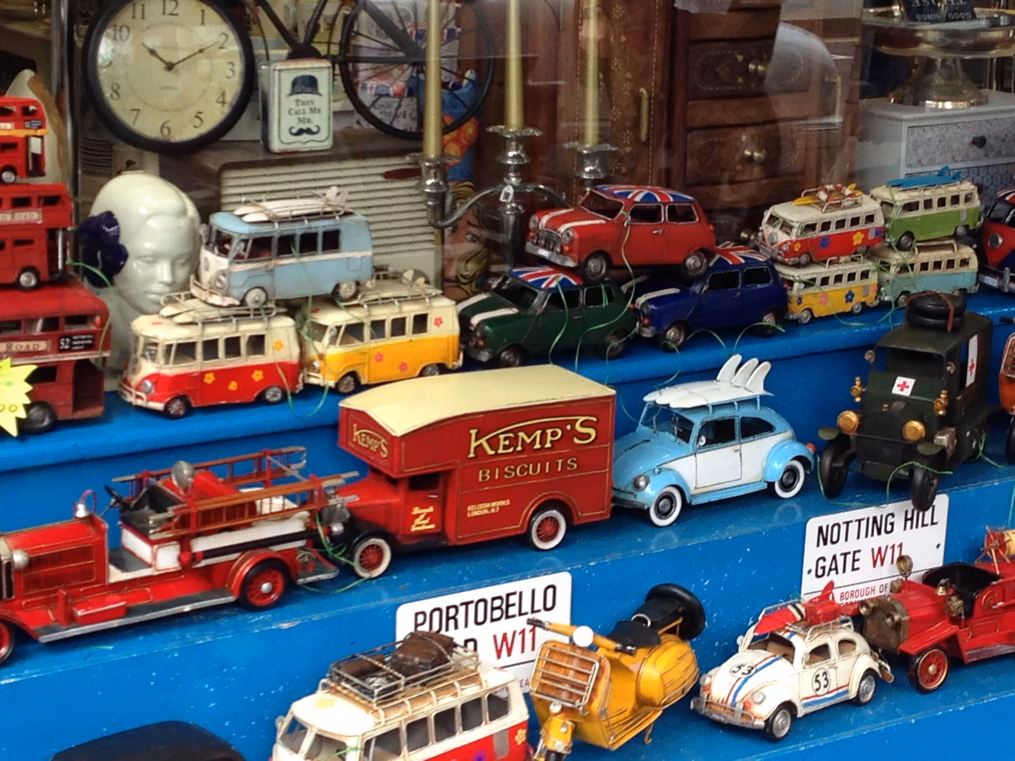 Vintage toy buses, cars and clocks displayed in a Portobello Road shop window